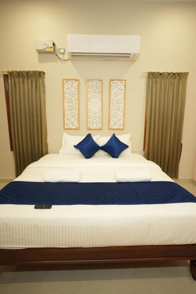 Deluxe Villa king bed with carved wall panels above the headboard